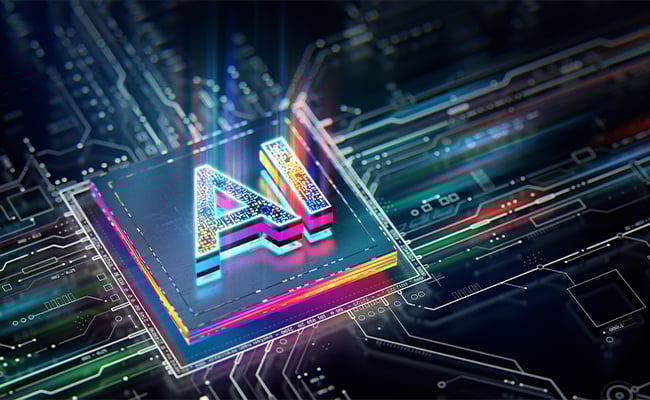Zoomed in computer chip with the letters AI in bright rainbow colors.
